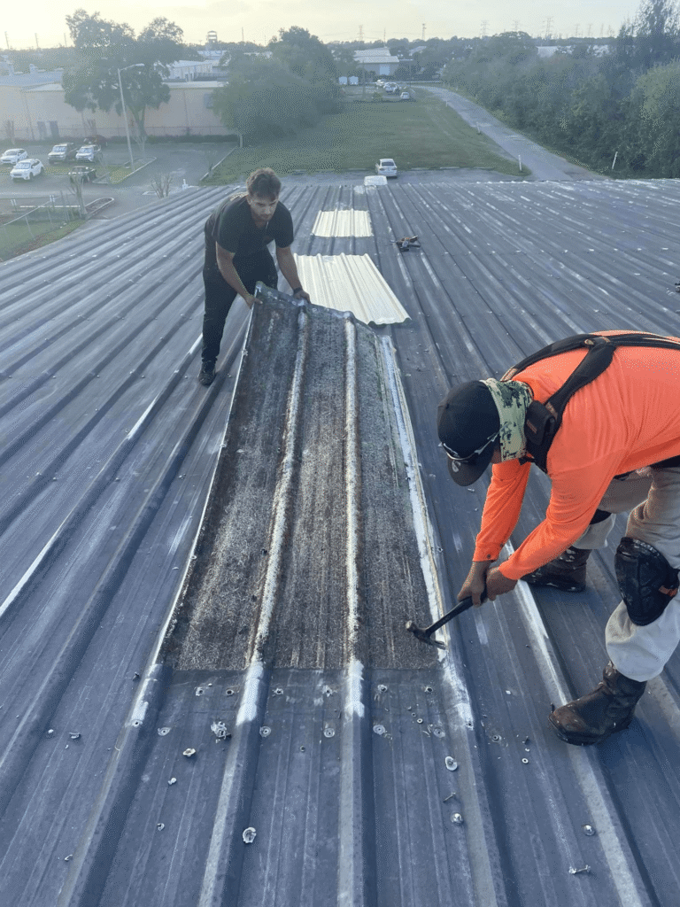 Roofing professional applying a patch repair on a commercial roof to prevent further damage.