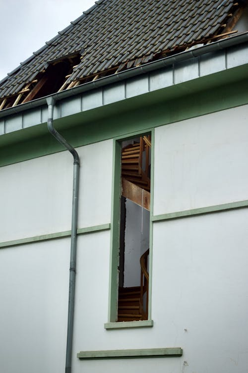 residential roof with visible storm damage and missing shingles