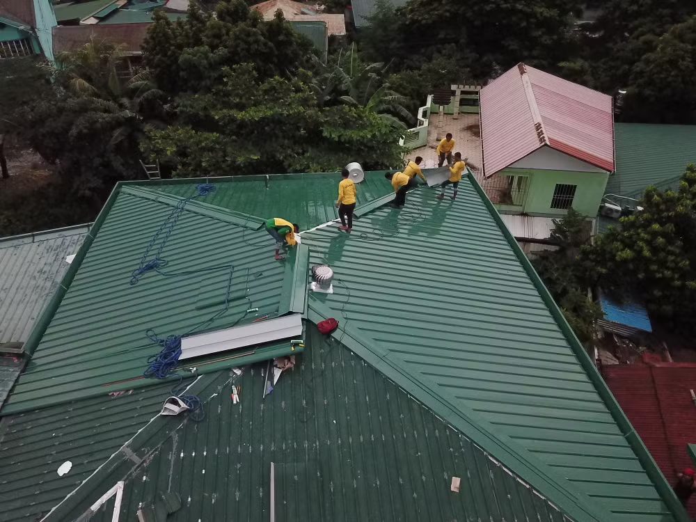 Roofers working on a metal roof