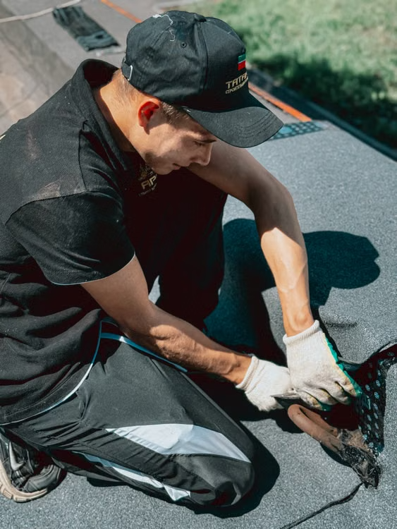 a man applying waterproof membrane on top of a roof