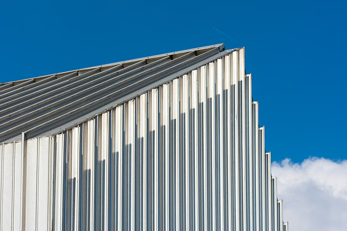 a metal roof of a building under the blue sky