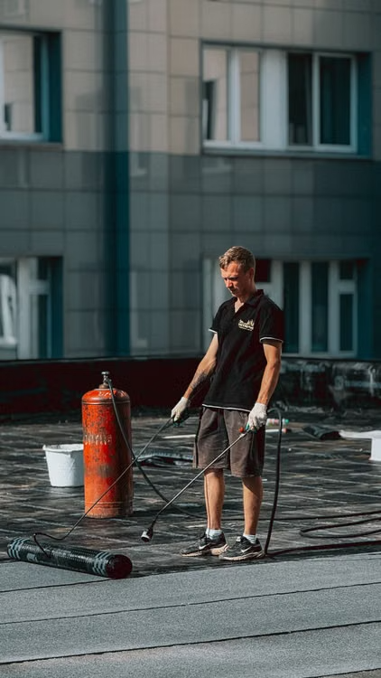 a man working on top of a roof for maintenance